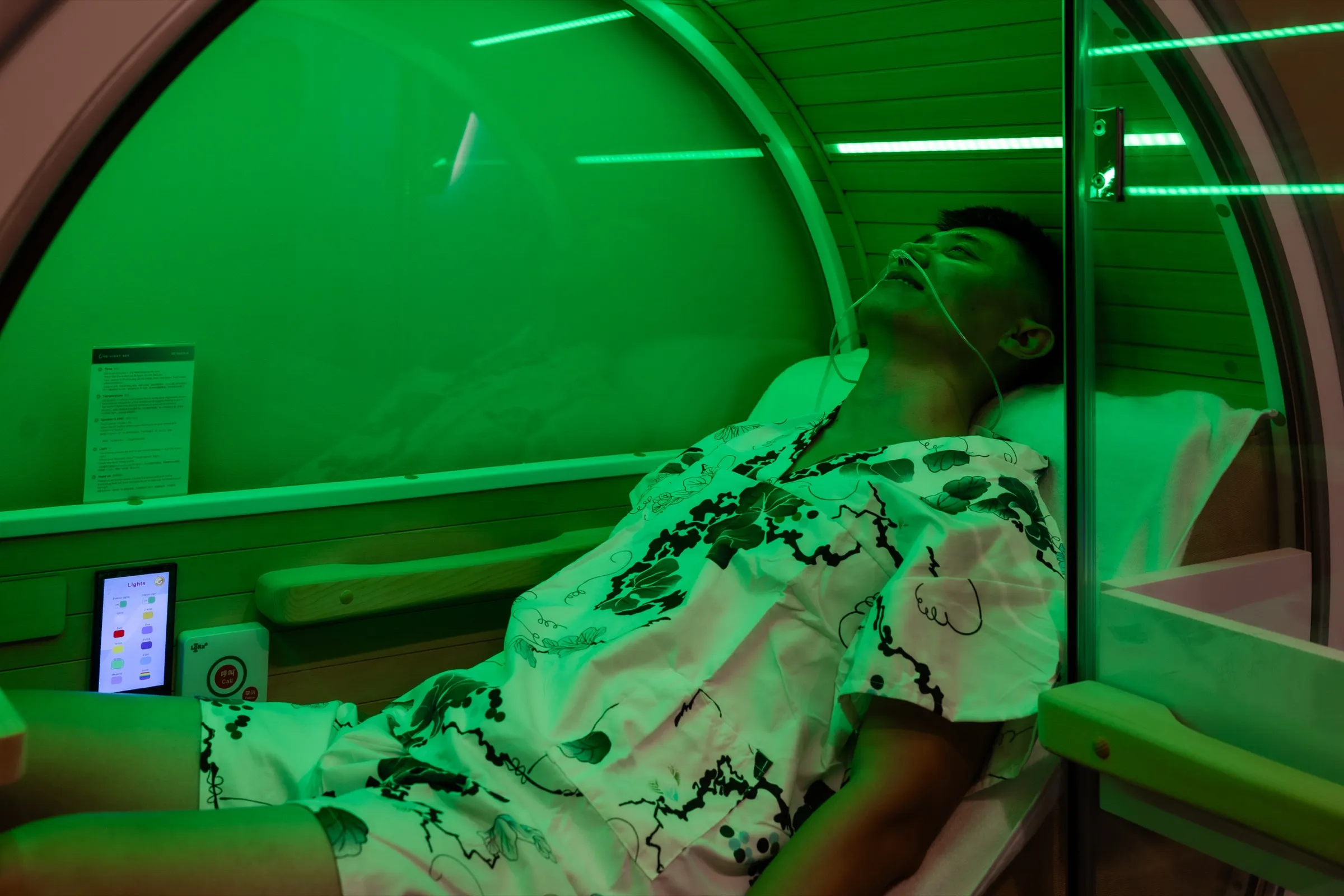 Guest reclining in a private O2 Oasis capsule at O2 Light Bar Singapore, breathing high-concentration oxygen